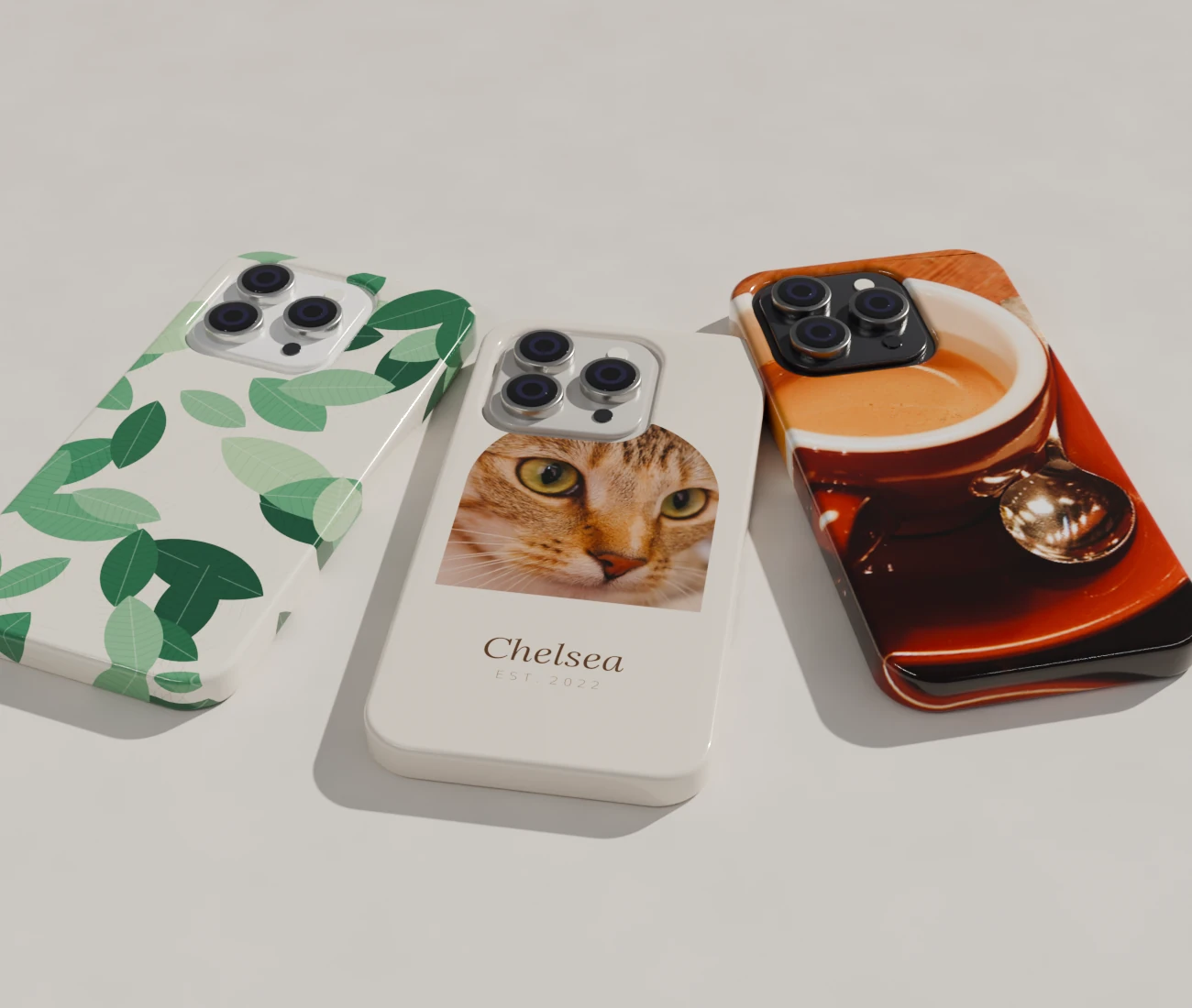 Three Caseiton cases on a stone table: a pet portrait with a name, a leaf print, and a coffee photo printed edge to edge